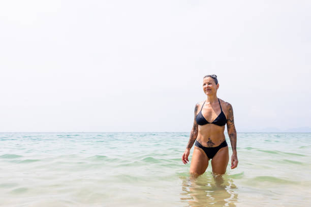 istock Mature woman in bikini at the beach 2200552090