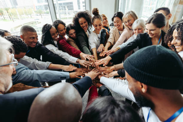 istock Corporate team with hands united celebrating success and teamwork in modern office environment 2200552309