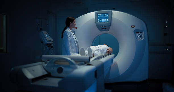 istock In Medical Laboratory, Radiologist Controls MRI or CT or PET Scan with Patient Undergoing Procedure. Professional Female Doctor Conducts Emergency Check Up Procedure with Advanced Medical Technologies 2200552644