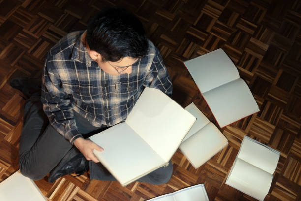 Man carrying a stack of books