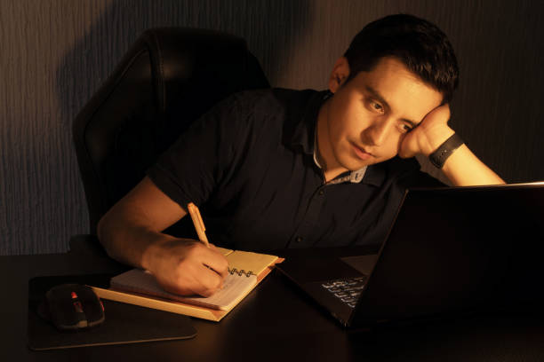 istock Young Man Reflecting While Working Late at Night on a Laptop 2200553642