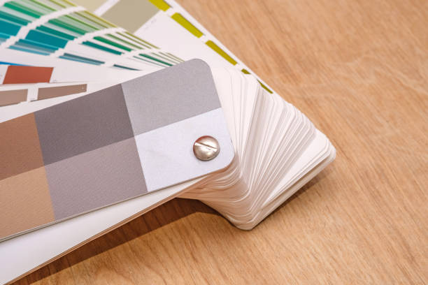 istock Color swatch book with paint samples on wooden surface. 2200553853