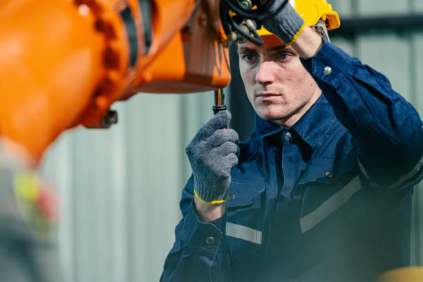 istock Young technician repairs an industrial robotic arm in a manufacturing facility 2200562142