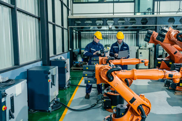 istock Engineers inspect robotic arms during equipment testing in a modern manufacturing facility 2200562196