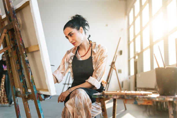 istock Young Female Artist Concentrating in Bright Studio 2200566293