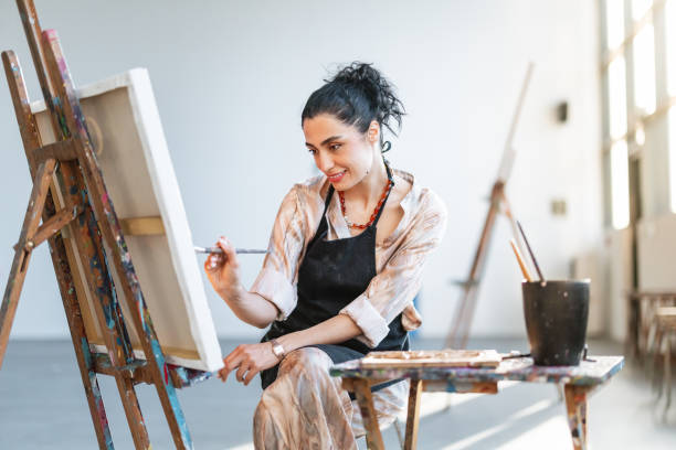 istock Young Female Artist Painting in Sunlit Studio 2200566297