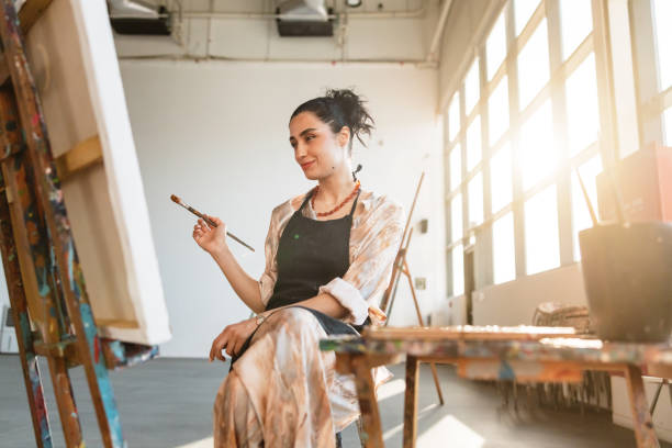 istock Young Female Artist Painting in Sunny Studio 2200566301