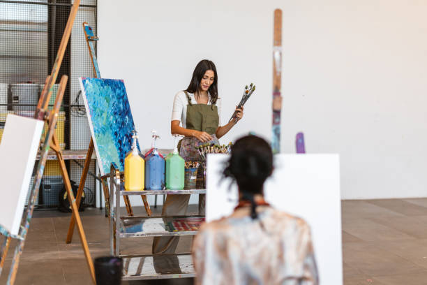 istock Young Middle Eastern Woman Leading Art Class with Diverse Group 2200566329