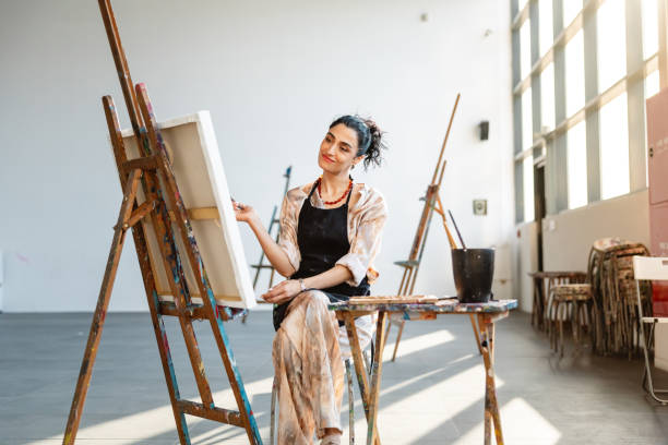 istock Determined Female Artist Painting in Bright Studio 2200566424