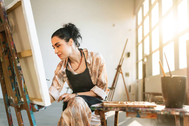 istock Young Middle Eastern Female Artist Painting in Studio 2200566427