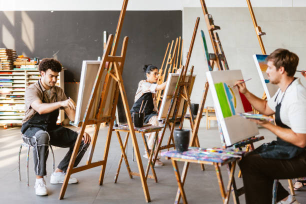 istock Diverse Artists Engaged in Vibrant Studio Painting 2200566471