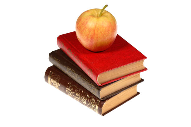 A stack of old books with apple isolated on white background. Selective focus