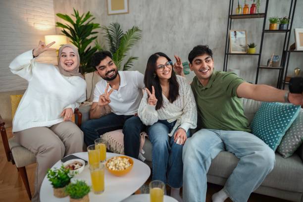 istock Four friends taking a selfie on the sofa at home 2200570003
