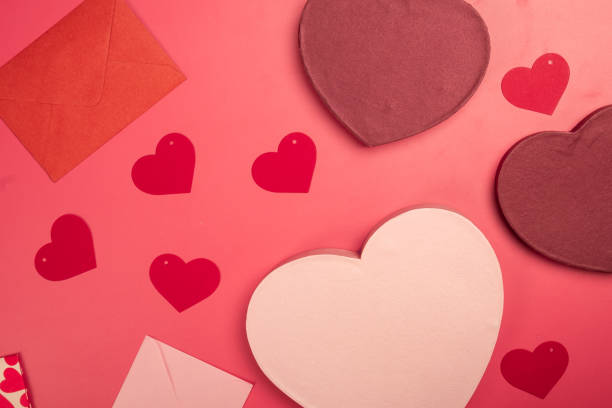 istock A flat lay Valentine's Day composition featuring heart-shaped gift boxes, paper hearts, envelopes, ribbons, and origami hearts on a red background, symbolizing love, romance, and celebration 2200570213