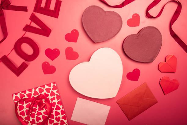 istock A flat lay Valentine's Day composition featuring heart-shaped gift boxes, paper hearts, envelopes, ribbons, and origami hearts on a red background, symbolizing love, romance, and celebration 2200570681