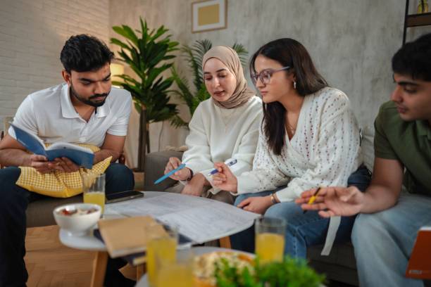 istock Young students studying together at home sitting on a sofa 2200571238