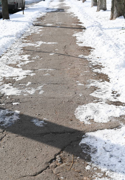 istock Cracked Sidewalk with Snow and Shadows 2200572960