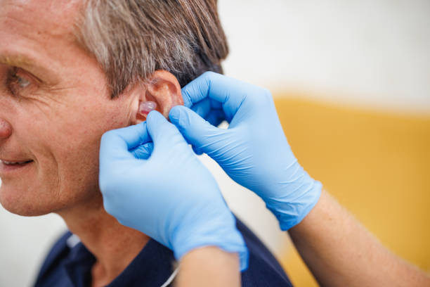 istock Mature Caucasian Male Receiving Custom Hearing Aid Fitting 2200573191