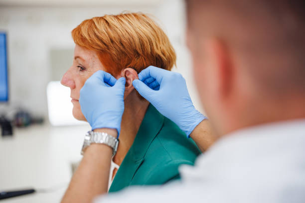 istock Senior Woman Receiving a Hearing Aid Adjustment 2200573221