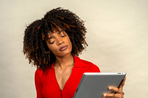 istock Young woman reading information on digital tablet with serious expression 2200574015