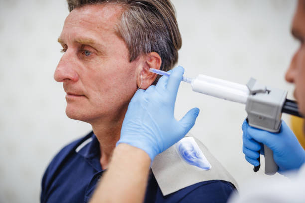 istock Young Audiologist Molding Hearing Device for Mature Male 2200574294
