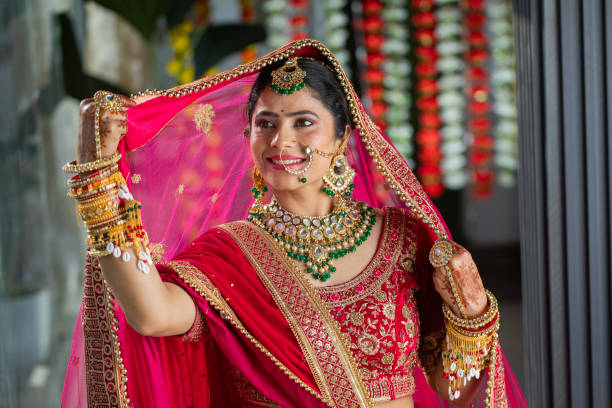 istock Beautiful bride with red veil on her head posing in wedding ceremony 2200577000
