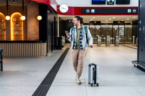 istock Young man passenger using phone at the train station 2200581343
