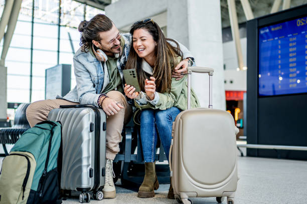 istock Couple using phone at the train station 2200581834