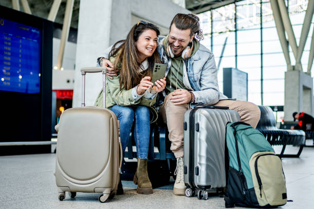 istock Couple using phone at the train station 2200581845