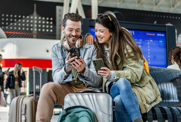 istock Couple using their phones at the train station 2200581866