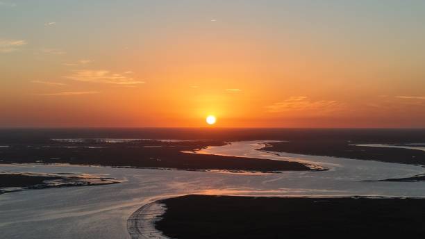 istock Serene sunset over a winding river, casting warm hues across the landscape 2200581956