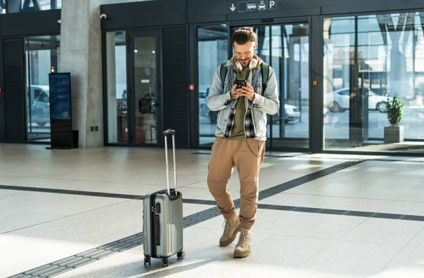 istock Young man passenger using phone at the train station 2200582129