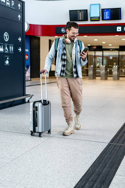 istock Young man passenger using phone at the train station 2200582148