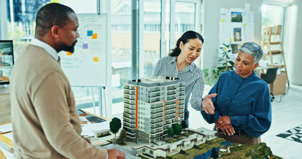 istock Business people, architect and team with 3D model for project planning or real estate design at office. Group, employee or interior designers with prototype for meeting or industrial development 2200585541