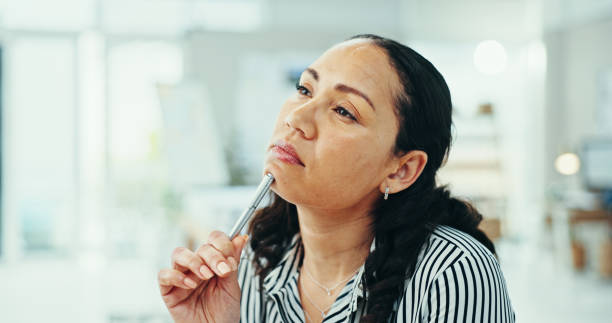 Business woman, thinking and pen with decision for problem solving, solution or ideas at office. Female person, creative or thoughtful employee with wonder or thought for choice or contemplating