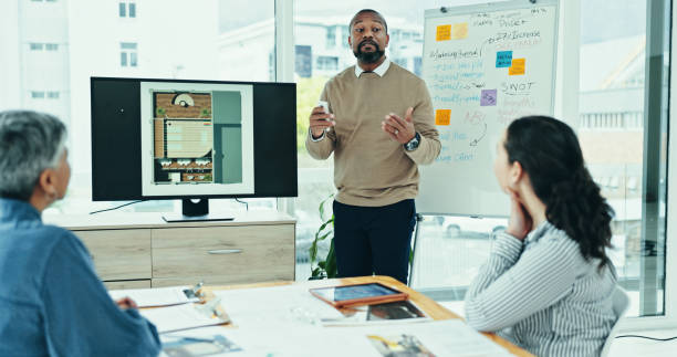 istock Businessman, discussion or meeting with screen for presentation, interior design or floor plan at office. Man, architect or designer talking with team or display for renovation or construction layout 2200585621