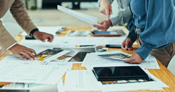 istock Architects, hands and meeting with documents, planning and agency for creative partnership. Business people, tablet and engineering for blueprint, brainstorming or problem solving for startup office 2200585626