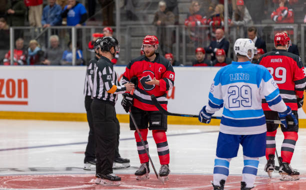 istock Professional Hockey Players in Red and Blue Uniforms Discuss with Referee 2200585931