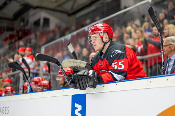 istock Professional Hockey Player in Red Jersey Watching Game from Team Bench 2200586053