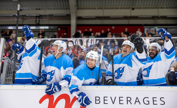istock Excited Ice Hockey Team Celebrating Victory on Bench 2200586108