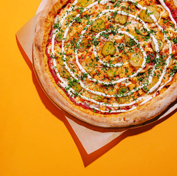 istock Delicious pizzas displayed on a vibrant orange background, showcasing cheese and unique toppings with fresh ingredients 2200588365