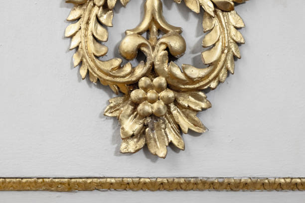 istock Gold Ornamental Design Element Featuring Decorative Floral Motif on White Wall 2200589353
