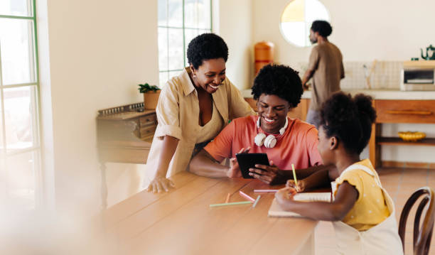 istock Happy family learning together at home using technology 2200589812