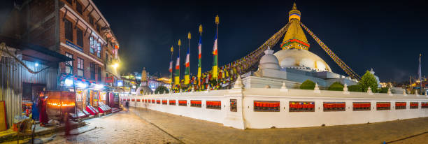 Pilgrims swirling round the iconic dome and prayer flags of Boudhanath Stupa in Kathmandu, Nepal.