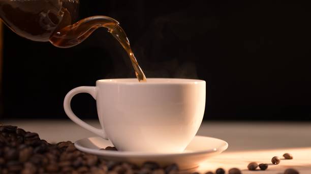 istock Pouring hot espresso into a coffee cup cozy kitchen setting beverage steam rising concept of comfort with hot coffee and tea 2200591703