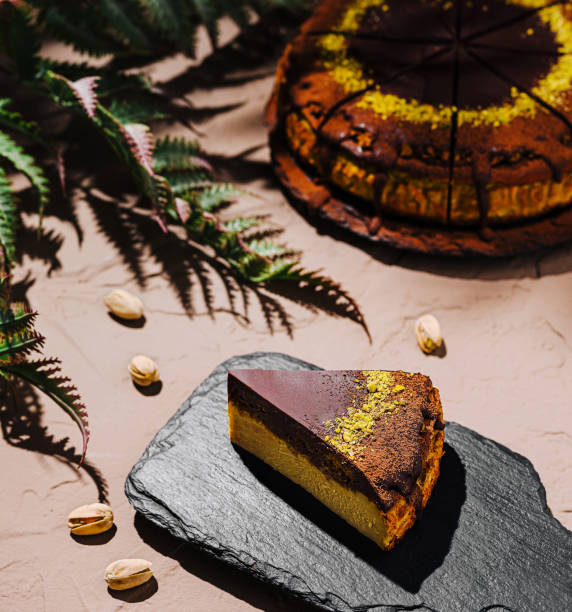 istock Delightful slice of layered cake served on a rustic black slate board with decorative green leaves in natural light 2200593778