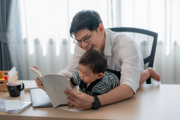 istock Father and child share quality time reading together at home in a cozy study 2200597474