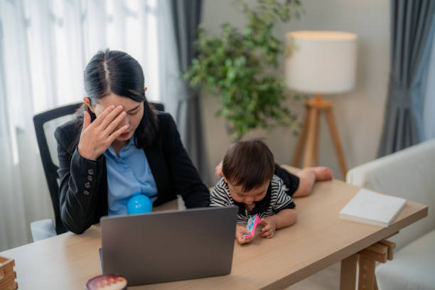 istock Busy working mother managing stress while caring for young child at home office 2200598156