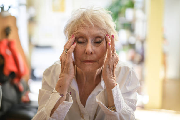 istock Beautiful senior woman in the kitchen having headache 2200600752