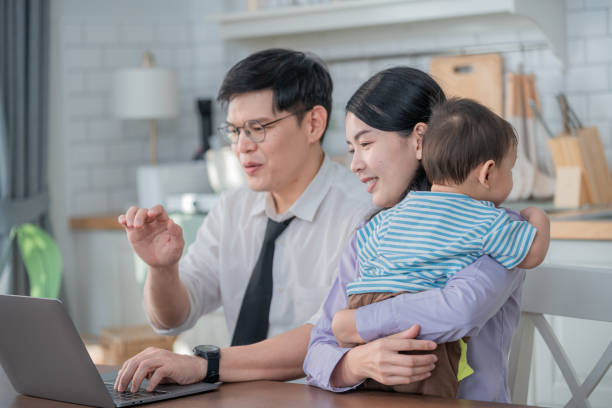 istock Parents engaged in remote work while caring for their toddler in a bright, modern home office space 2200602453
